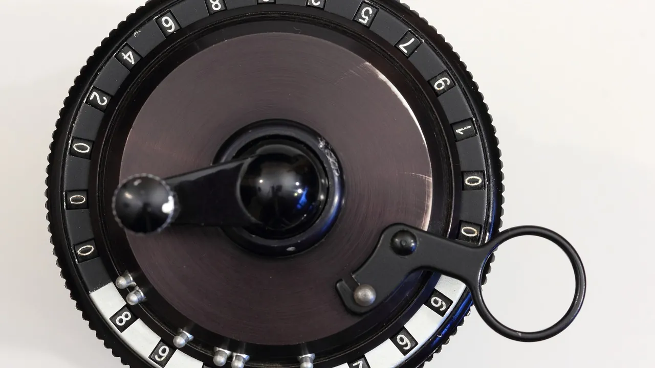 Une calculatrice mécanique à manivelle, sa couronne chiffrée vue de dessus