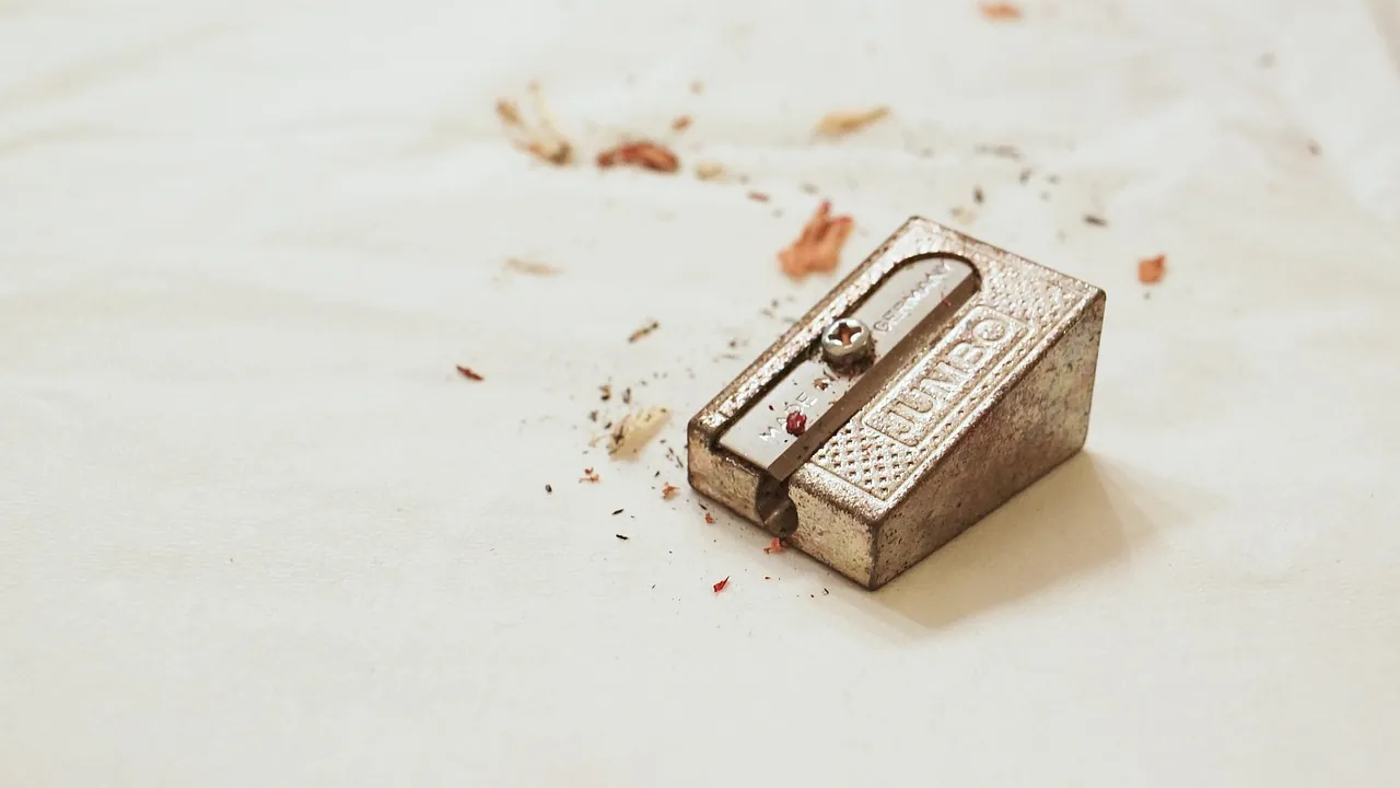 Un taille-crayon en métal entouré de copeaux de bois